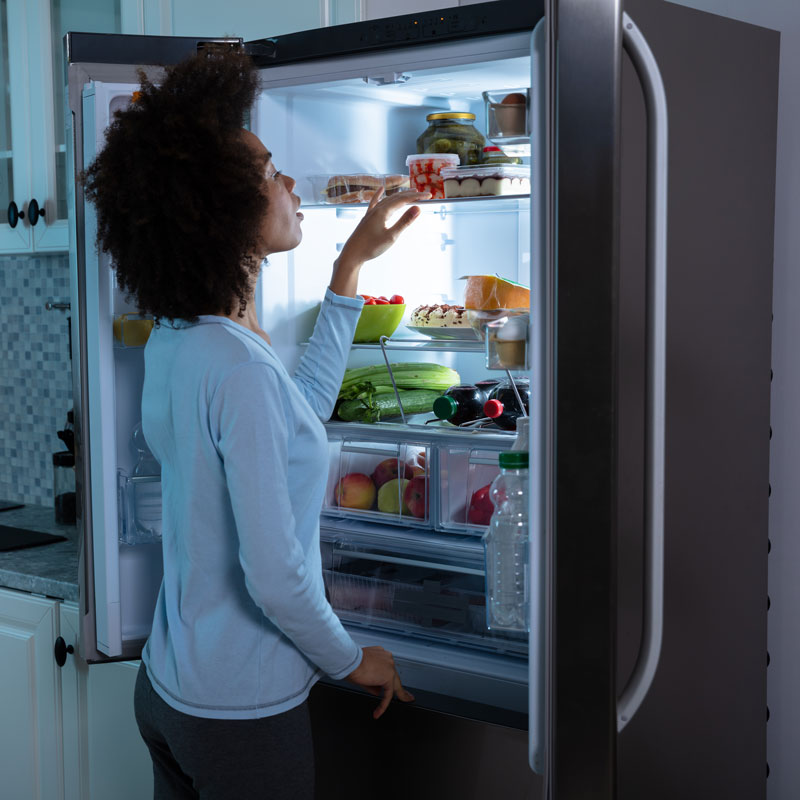 Lady checking the Refrigerator from inside