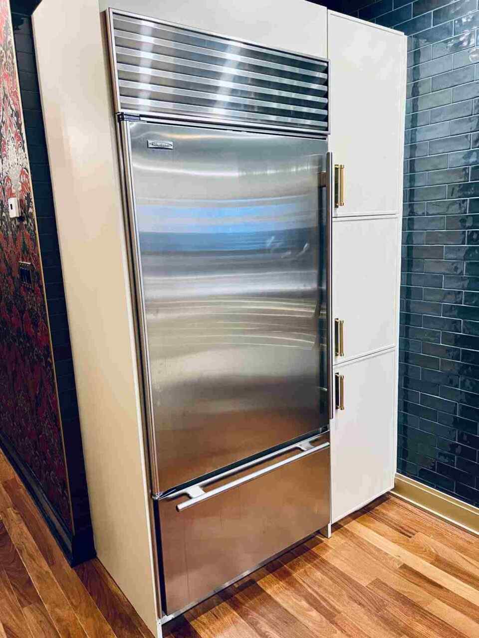 Built-in stainless steel Sub-Zero refrigerator in a modern Chicago-area kitchen with white cabinets