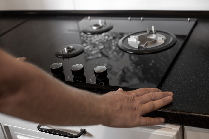 Kitchen cooktop being inspected during professional repair service in Chicago, IL