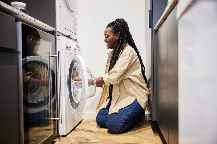Woman servicing a washing machine during professional dryer cleaning in Chicago, IL