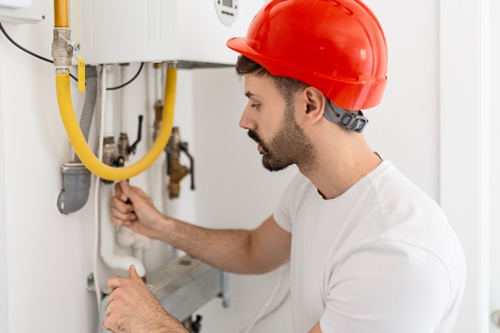 Technician repairing a water heater, serving Chicago and the surrounding suburbs